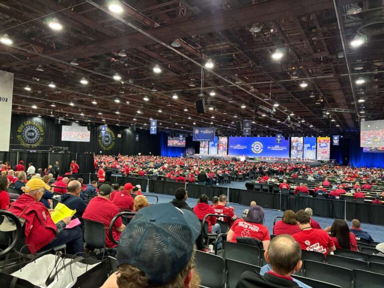 UAW Constitutional Convention, big hall with hundreds of delegates seated, wearing red
